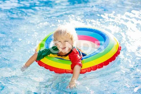 Child in swimming pool on toy ring. Kids swim. Stock Photos