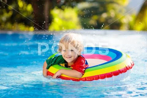 Child in swimming pool on toy ring. Kids swim. Stock Photos
