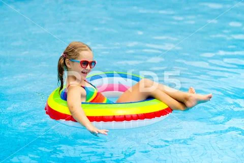 Child in swimming pool on toy ring. Kids swim. Stock Photos