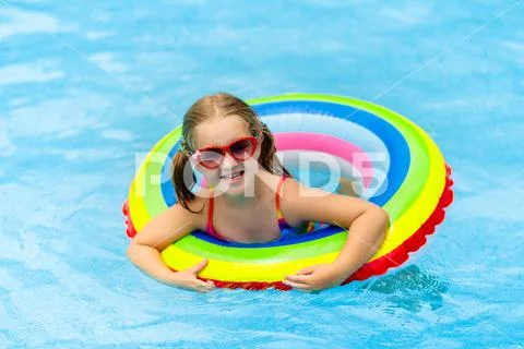 Child in swimming pool on toy ring. Kids swim. Stock Photos