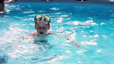 Child swimming in a swimming pool while people practicing water aerobics Stock-Footage 136814087