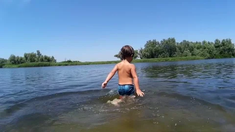 Child swims alone in muddy river water Stock Footage 77204966