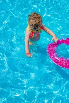 A child swims in a pool with a circle. Selection focus. Stock Photos
