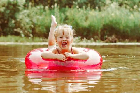 A child swims in the river in an inflatable circle Stock Photos