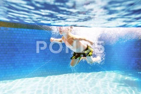 Child swims in swimming pool with mask Stock Photos