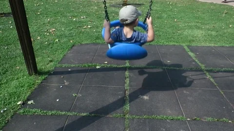 Child on the swing in the public park Stock Footage 77599321
