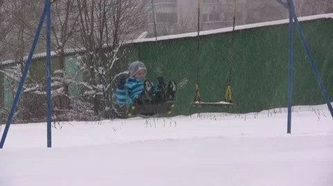 Child on the Swing. Snowy Stock Footage 45414254