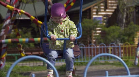Child on swing in spring park Stock Footage 62500499