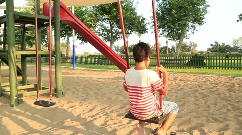 Child swinging at the playground Stock Footage 66457950