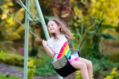 Child swinging on playground. Kids swing. Stock Photos