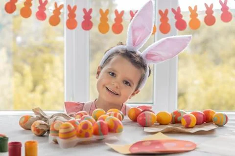 Child at a table decorated for a happy Easter. boy has fun preparing for Easter Stock Photos