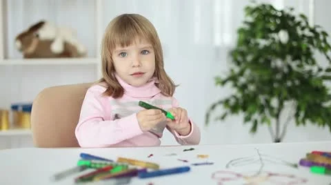 Child at a table looking at camera Stock Footage 8975177