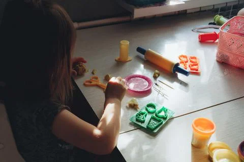 The child at the table sculpts with plasticine Stock Photos