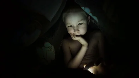 Child with a tablet on the bed, under the blanket Stock Footage 74965211