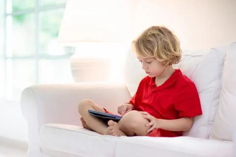 Child with tablet computer. Kids study online. Stock Photos