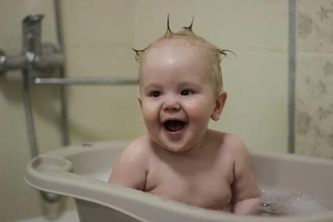 The child takes a bath and laughs. Stock Photos