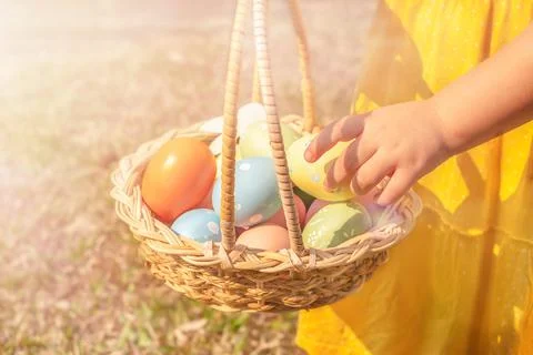 A child takes out an Easter egg from a basket Stock Photos