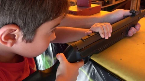 Child taking aim at rifle saloon Stock Footage 116173183