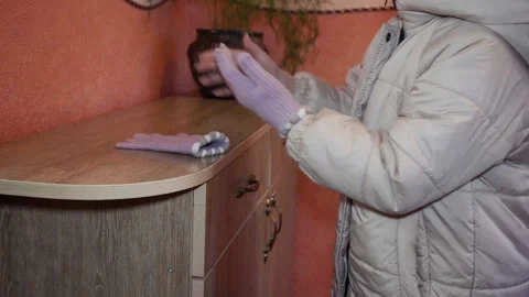 Child taking off winter gloves after playing outside Video stock 330257966