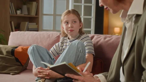 Child Talking to Therapist while Specialist Writing Assessment Notes at Home Stock Footage 334341567