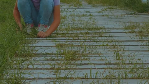 The child tears the grass, pluck the grass Видео 331852308