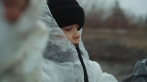 Child tests protective gear. Young child checks gas mask carefully at deserted Video stock 342743289