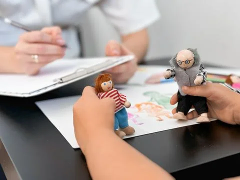 Child therapy session with therapist using puppet play for emotional expression Foto stock