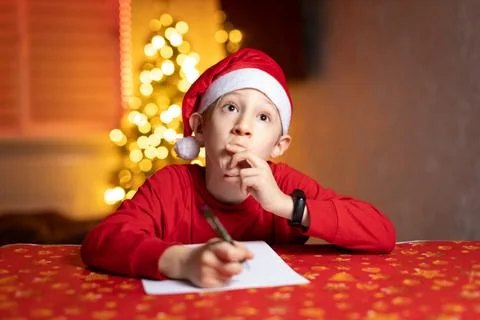 The child thinks what to write in a letter to Santa Claus Stock Photos