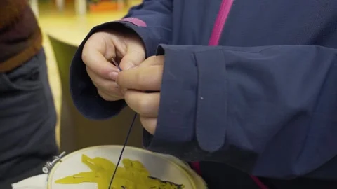 A child threading a needle at an arts and crafts workshop Stock Footage 229579075