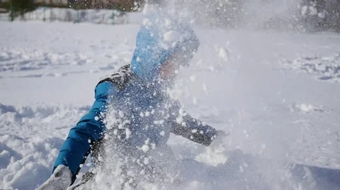 Child throwing snow over himself and smiling it in the winter park Vidéo 68952994