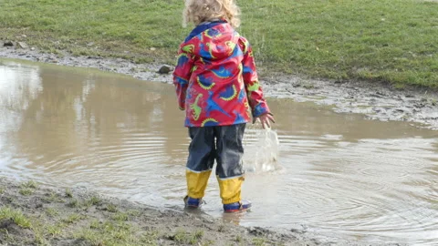 Child throwing stones to the puddle. Stock Footage 149989077