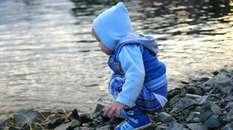 Child throwing stones into the river Vidéo 66061024