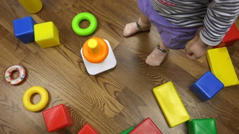 A child throws multicolored plastic toys on the floor Stock Footage 96410913