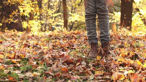 Child throws up scatters leaves and rotates around its axis in the autumn forest Stock Footage 199407406