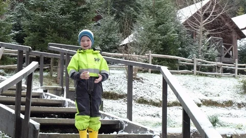 A child throws snow in the forest, Carpathians Ukraine. Child in ski clothes Stock Footage 102881229