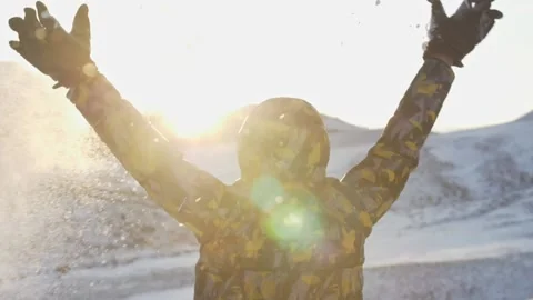 A child throws snow with his hands against the background of snow-capped mountai Stock Footage 151154151