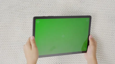 Child tilting to the left and right a tablet with green screen, top view Stock Footage 255507159