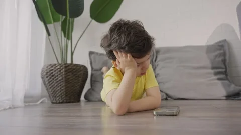 Child tired after using cellphone and playing online games Stock Footage 245513218