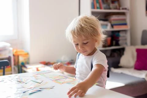 Child toddler boy playing developing games, learning alphabet and numbers, ed Stock Photos