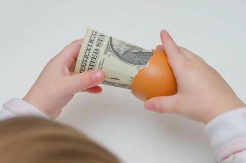 A child took a dollar in an egg shell on white background Fotos de archivo