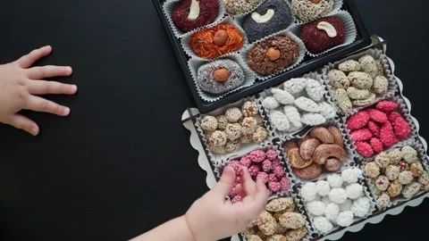 The child touches the persimmon nut candy. Natural sweets without sugar. Video stock 235322746