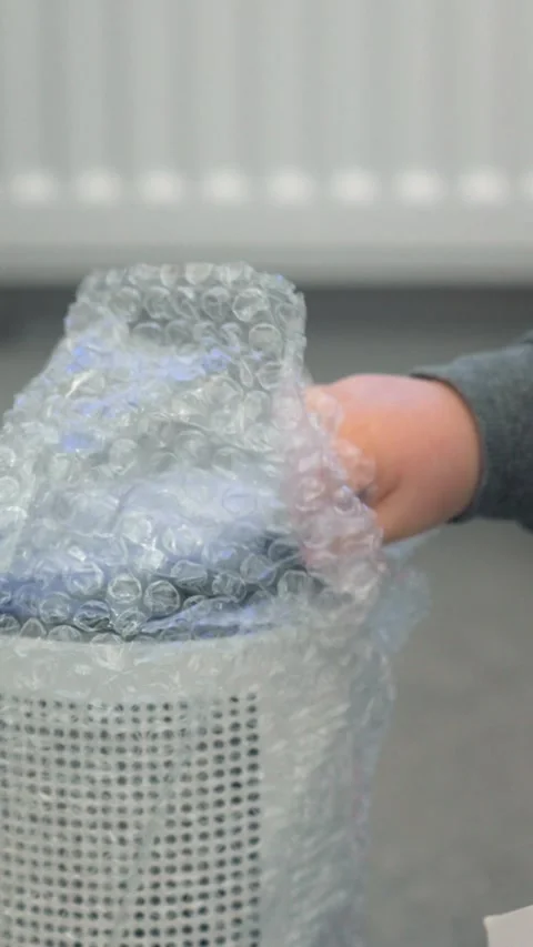 Child Touching Bubble Wrap on Device Holding Box Stock Footage 327481951