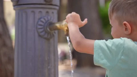 Child Touching Public Drinking Water Fountain in City Park Stock Footage 340361967