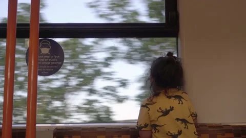 Child on train ride looking out the window during covid pandemic mask sign Stock Footage 170721643