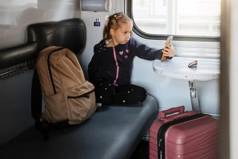 Child in train using smartphone while traveling Stock Photos