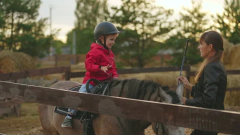 Child is training with equestrian instructor in pony club, riding horse and Stock Footage 213589196