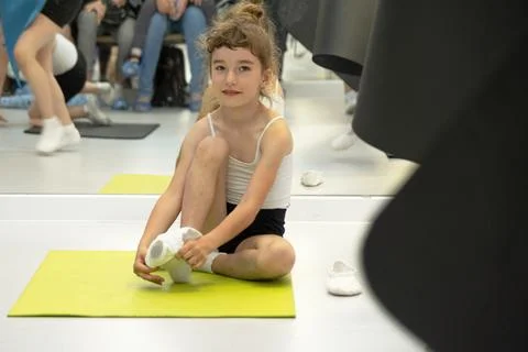 Child trains in gym on the mat, does stretching exercises and abs, gymnastics Foto stock