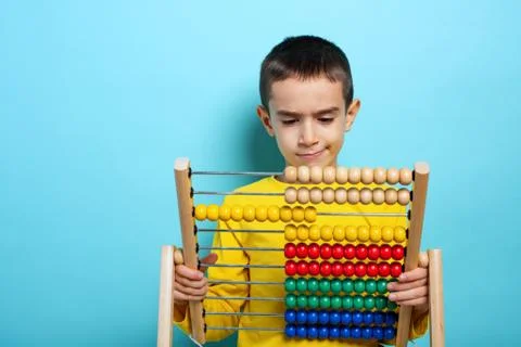 Child tries to solve mathematical problem with abacus. Cyan background Stock Photos