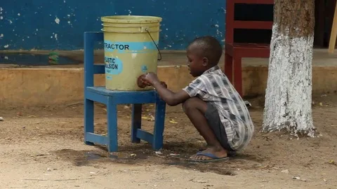 Child tries the water from an empty bin Stock Footage 69228572