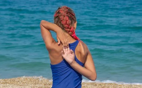 Child trying to bring both hands together behind the back, one from above t.. Stock Photos